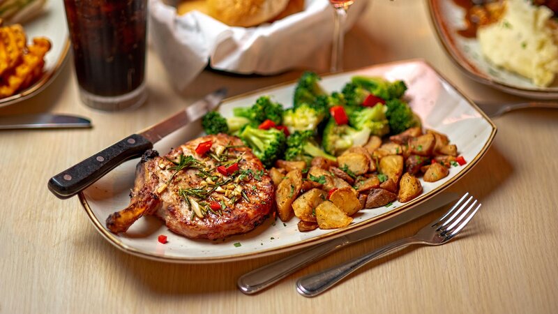 Steak entree with side of fried potatoes and broccoli